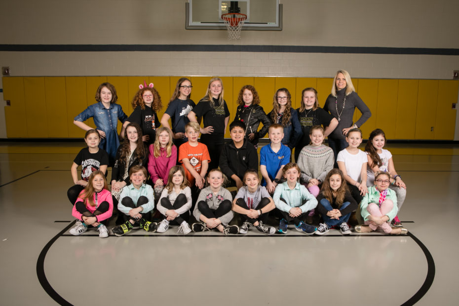 Traditional class photo by Schoolhouse Photos: a class posed together with their teacher in the school gym