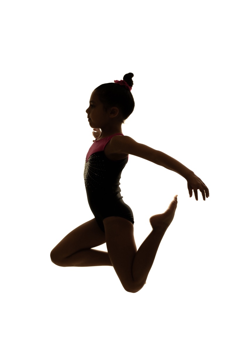 Action silhouette of a young gymnast leaping mid-air